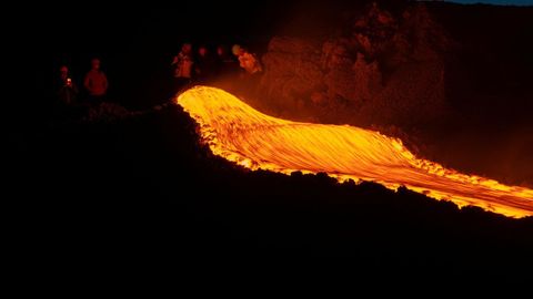 Un grupo de personas miran el flujo de lava del volc�n Etna