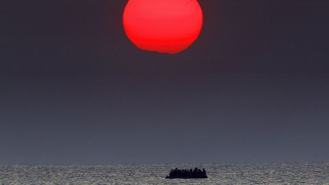 Un sol rojo sobre un bote abarrotado de refugiados sirios a la deriva en el mar Egeo entre Turqu�a y Grecia. 