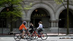 Unos ciclistas pasan por delante de la entrada del hotel Trump en Washington