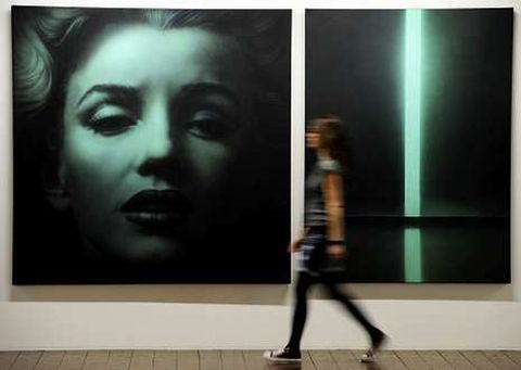 Una mujer pasa ante un retrato de Marilyn en una obra del artista ruso Timofeev.