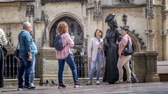 Turistas se sacan una foto con la estatua de La Regenta, situada al frente de la catedral de Oviedo