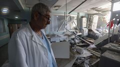 Un sanitario observa los da�os en el hospital Jabal Amel de Tiro, en el L�bano, a causa del bombardeo en un edificio pr�ximo por parte del Ej�rcito de Israel