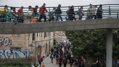 Miles de personas cruzan el puente que llega hasta el valenciano barrio de La Torre para distribuirse por los municipios afectados.