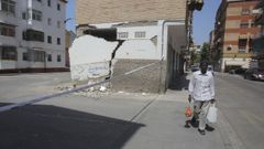 Un hombre pasa junto a una vivienda con desperfectos causados por los terremotos en Granada. 
