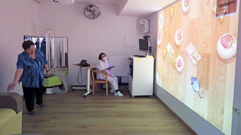 Elvira Villar, de 84 a�os, intentando alcanzar un rat�n en uno de los juegos de Rehametrics.