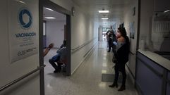 Una mujer muestra su hombro a una enfermera antes de recibir la vacuna esta ma�ana en el hospital de Monforte