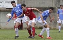 El capit�n sofanista, Bert�n, disputa un bal�n con dos rivales del l�der Villestro en O Carral. 
