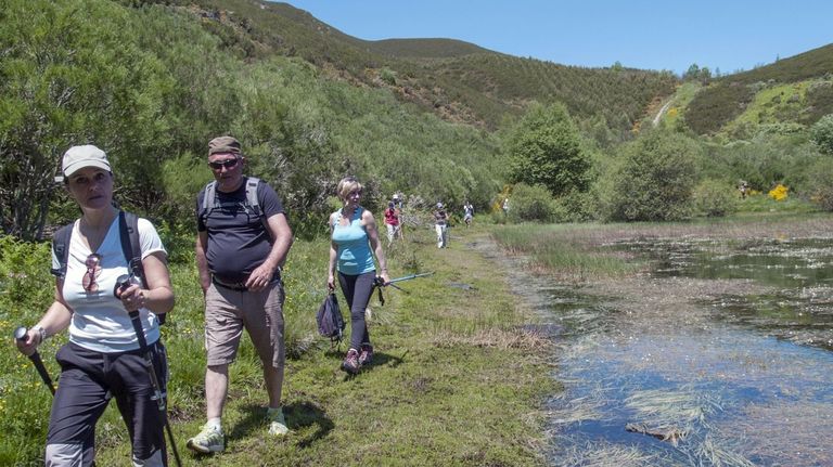 Un grupo de visitantes pasando junto a la laguna glaciar de Lucenza, en Quiroga