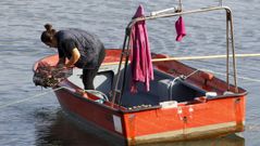 Un mariscador a flote trabaja en la r�a eumesa, en una fotograf�a de archivo