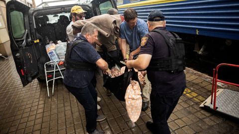 Polic�as y voluntarias trasladan a una mujer hacia uno de los trenes de evacuaci�n de civiles desde Pokrovsk, en el este de Ucrania, a Le�polis y Dnipro