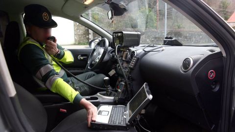 Un agente de la Guardia Civil, con un radar colocado en la AC-305 a su paso por Rianxo.