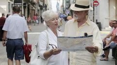 Dos cruceristas viendo un mapa de Ferrol en la calle Real