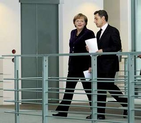 Merkel y Sarkozy se dirigen a la rueda de prensa una vez finalizada la reunin.