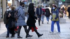 Varias mujeres con mascarilla caminando por el centro de Ribeira