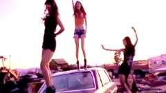 Chicas bailando sobre un coche