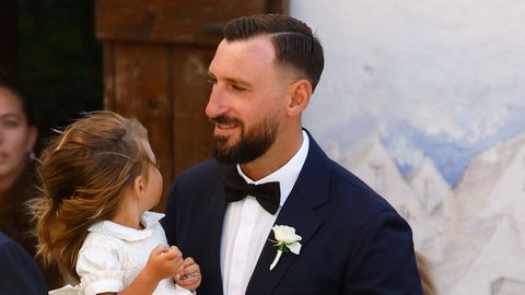 Antonio Donnarumma, hermano del novio, acude con su hija en brazos a la iglesia de San Giorgio Martire