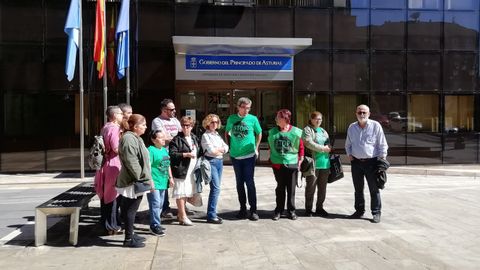 Los protestantes junto con la familia delante de la Consejera de Servicios y Derechos Sociales