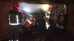 Voluntarios de Protecci�n Civil de Cedeira y personal del GES de Ortigueira, en el garaje que ardi� en Esteiro