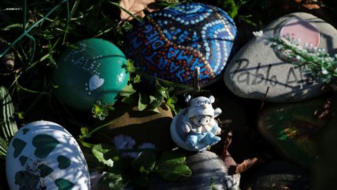 Varios objetos dejados a los pies del monumento de la Asociaci�n Brazos Vac�os en el Parque de Invierno (Asturias)