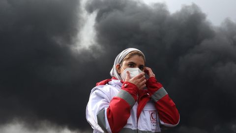 Una trabajadora de la Media Luna Roja, frente a las instalaciones petrol�feras atacadas. 