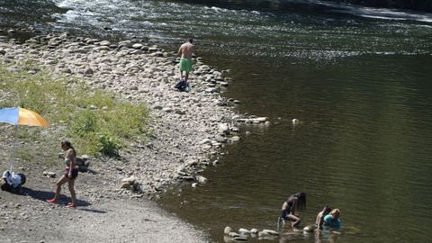 Unos ba�istas en una de las playas que forma en Las Caldas (Asturias) el r�o Nal�n