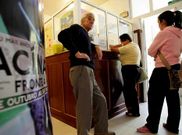 Tres personas esperan para pedir cita en el centro de salud de Arcade.
