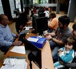 Una familia tramita su DNI o pasaporte en la comisar�a de Vigo. 