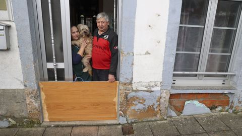 Isabel Salido y Ramiro Hermida con su perrito Tbet, en su casa donde colocaron compuertas para luchar contra las riadas de Neda