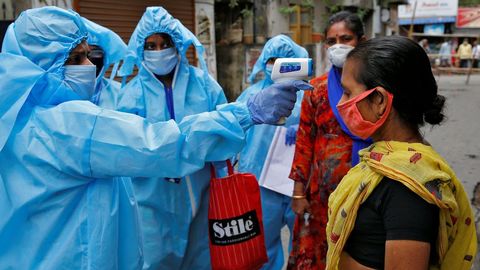 Profesionales sanitarios tomando la temperatura a una mujer en Calcuta