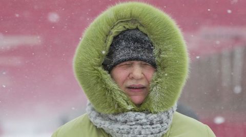 Una mujer camina bajo la nieve por el puente de Williamsburg en Nueva York