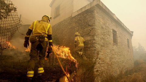 Personal de incendios tratando de sofocar el a�o pasado un incendio junto a las casas en la parroquia de Pombeiro, en Pant�n.