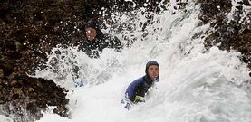 En la fotograf�a, dos percebeiros resistiendo una embestida del mar contra las rocas en el litoral de Cedeira.