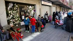 Los vecinos dejan flores y velas en el portal de la vivienda