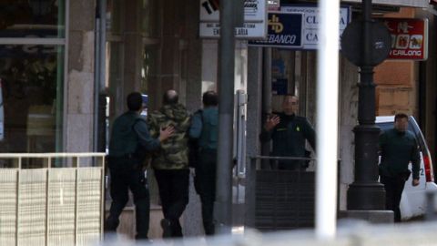 Rehenes saliendo de la sucursal de Cangas de Ons, tras al atraco