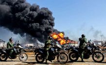 Unos agentes pasan cerca de una parte de la refiner�a de Amuay, en Venezuela.