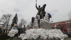 Varios voluntarios protegen con sacos de arena un monumento en la ciudad de Kiev