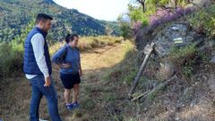 El edil Luis Manuel Arias, con la directora de un campo juvenil, examina un letrero deteriorado del Cami�o do Ferradal en el 2024