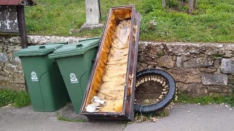 El atad tirado junto al contenedor