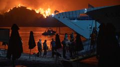 Evacuados en la isla de Eubea toman el ferri mientras el fuego sigue asolando la zona