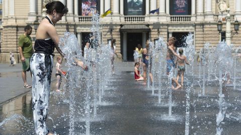 Una mujer se refresca en una fuente en Lviv, en Ucrania.