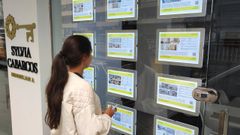 Una mujer consulta los precios de pisos en alquiler en una inmobiliaria gallega.