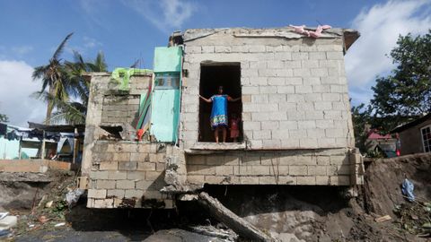 Una mujer observa desde la puerta de su casa los daños causados por el huracán Melissa en Alligator Pond (Jamaica)