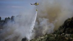 Un helic&oacute;ptero descargando agua en el incendio forestal declarado en el Concello de Culleredo. 