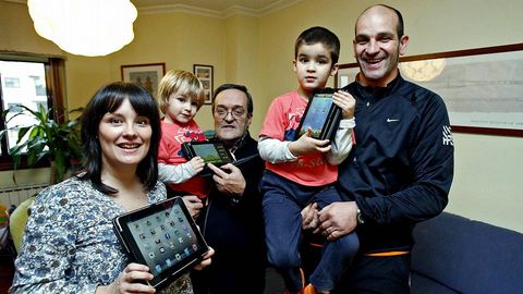 Beareiz Leclere sostiene un iPAd, mientras su hijo Juan (en brazos de su padre) ense�a su Bq Maxwell y el peque�o Mateo, de dos a�os, intenta arrebatarle al abuelo otra tableta