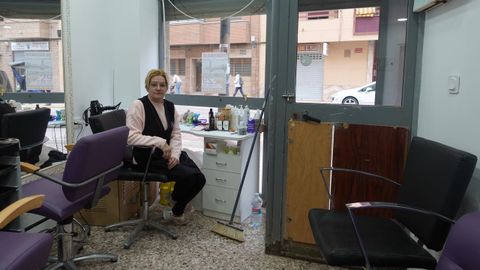 Carolina, sentada en su peluquera, est esperando a que vengan a darle presupuesto para la puerta.