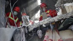 Equipos de rescate iran�es recogen un cuerpo en un edificio bombardeado en Teher�n.