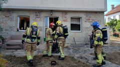 Efectivos de emergencias, durante la intervenci�n en la vivienda afectada por el incendio en el lugar de O Touro, en Ribeira