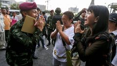 Un militar saluda a unas mujeres que se declaran en contra del golpe de estado en el monumento de la Victoria en Bangkok.