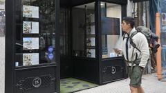 Un viandante pasa junto a una agencia inmobiliaria en el casco urbano de Santiago