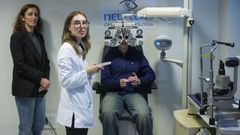 Un joven se revisa la vista en el primer d�a de funcionamiento del Plan Veo, el pasado 16 de diciembre. En la imagen, tambi�n la ministra de Sanidad, M�nica Garc�a.